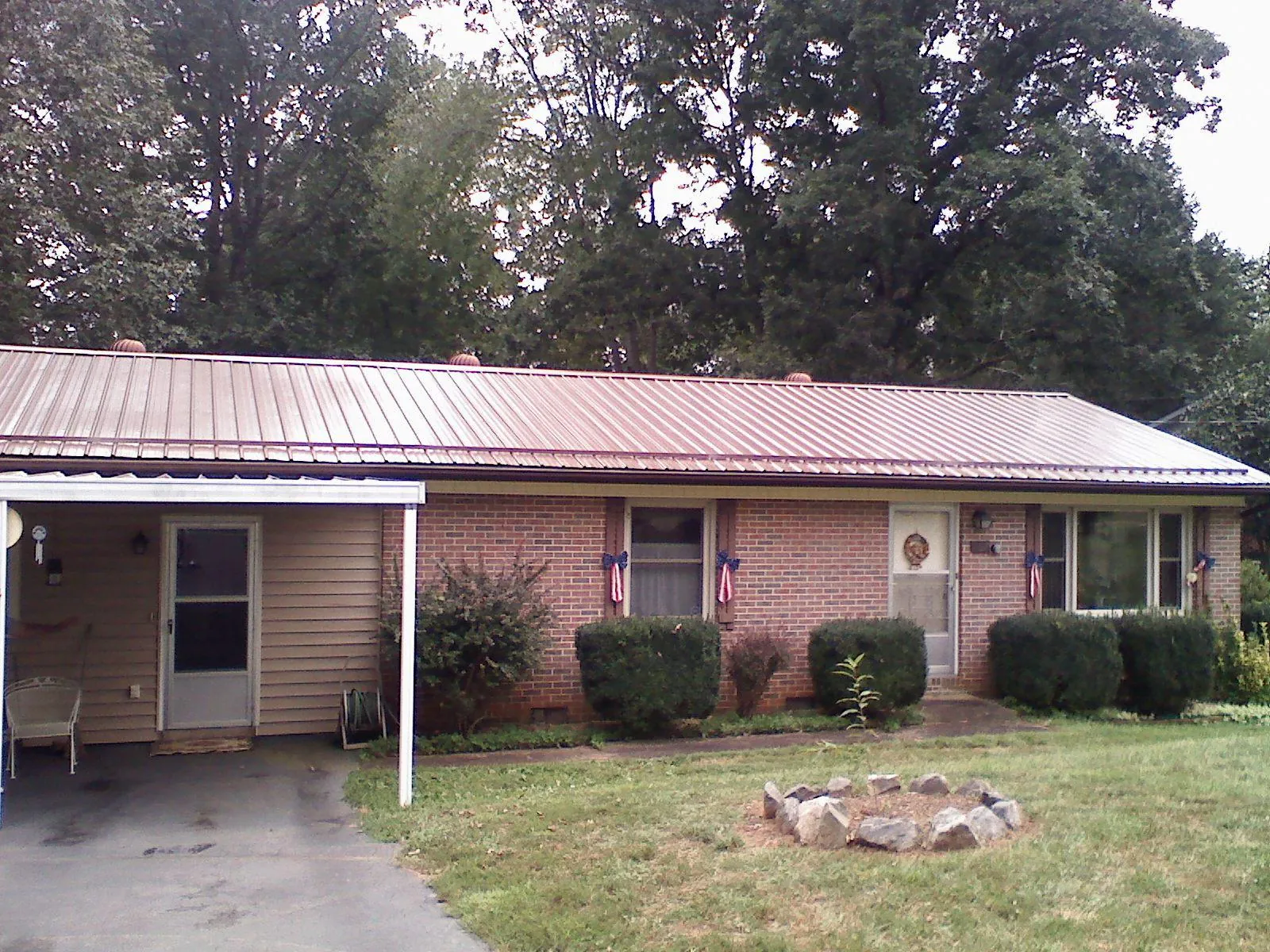Bronze metal roof and carport on a brick ranch home — Roof Repair work by our crew in Lovelock